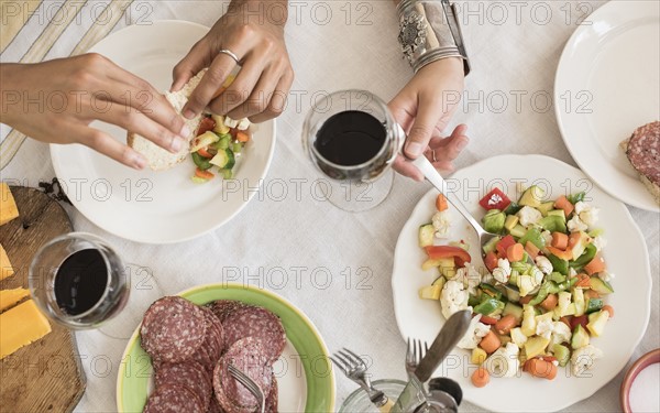 Hands serving salad.