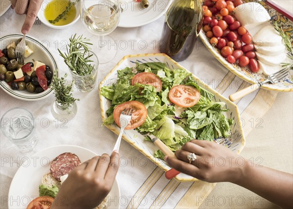 Hands serving salad.