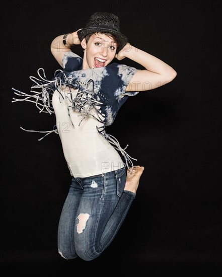 Portrait of young woman jumping.