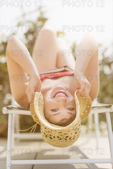 Portrait of young woman lying on beach chair.