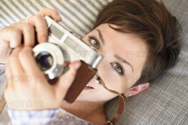 Portrait of young woman holding old fashioned camera.