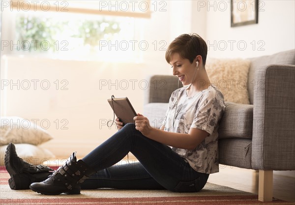 Young woman sitting on floor and using tablet pc.