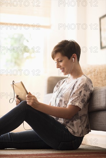 Young woman sitting on floor and using tablet pc.