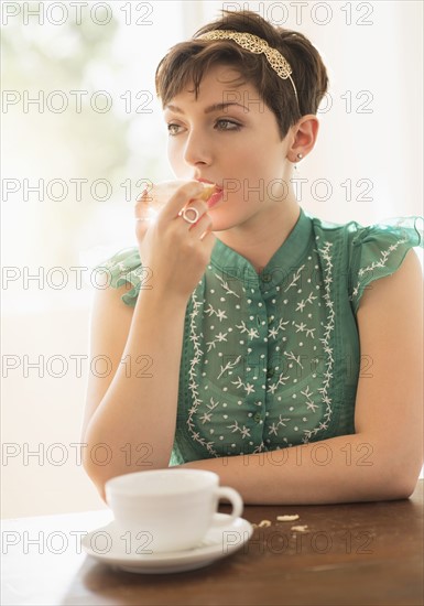 Portrait of brunette eating bread.