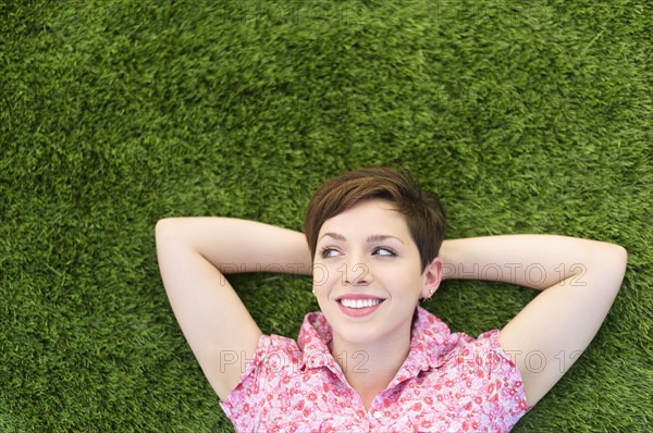 Young woman lying on grass.