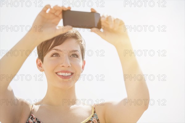 Young woman taking selfie with mobile phone.