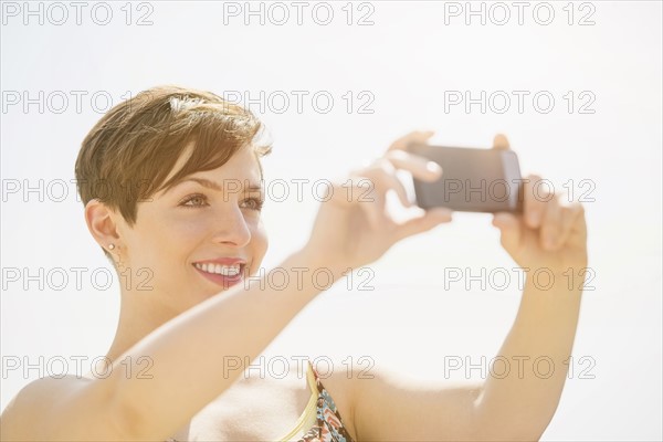 Young woman taking selfie with mobile phone.