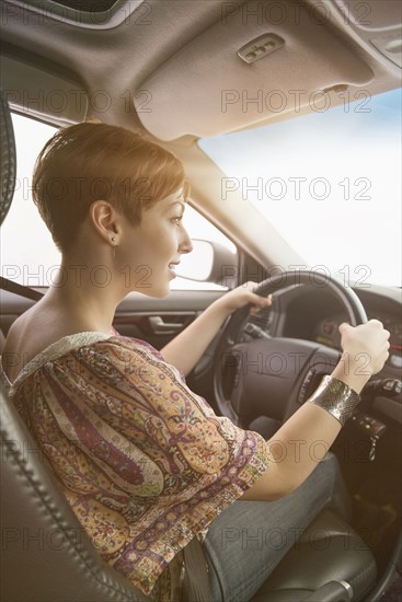 Side view of woman driving car.