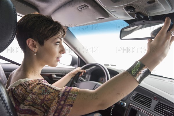 Side view of woman driving car.