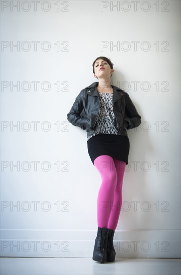 Woman wearing leather jacket, mini skirt and ping tights.