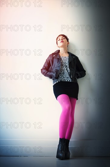 Woman wearing leather jacket, mini skirt and ping tights.