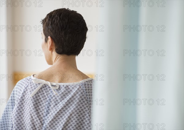 Rear view of senior woman wearing hospital gown.