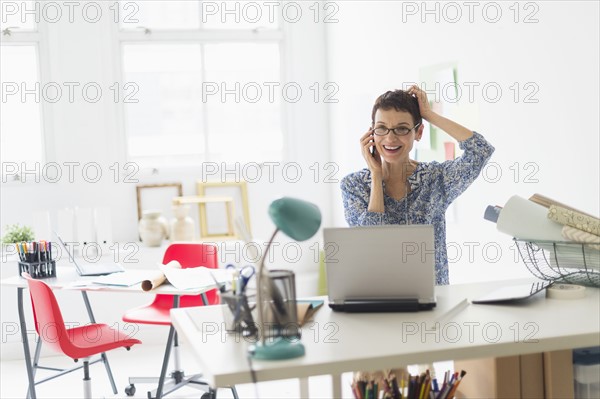 Senior business woman using cell phone in office.
