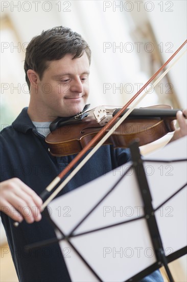 Man with down syndrome playing violin.