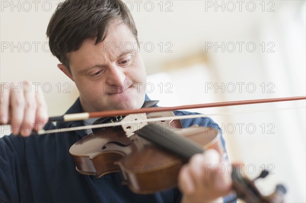 Man with down syndrome playing violin.