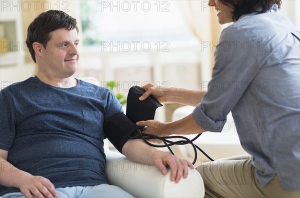 Man with down syndrome having blood pressure measured.