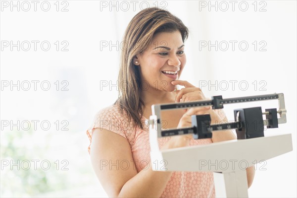 Happy woman standing on scale.