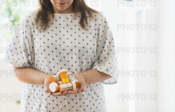 Woman with pill bottles in hands.