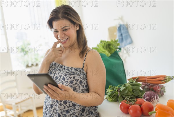 Woman with tablet pc in kitchen.