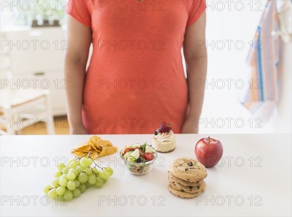 Woman standing by counter in kitchen.