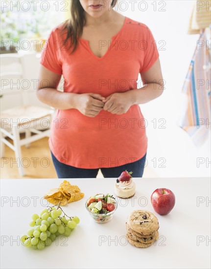 Woman standing by counter in kitchen.