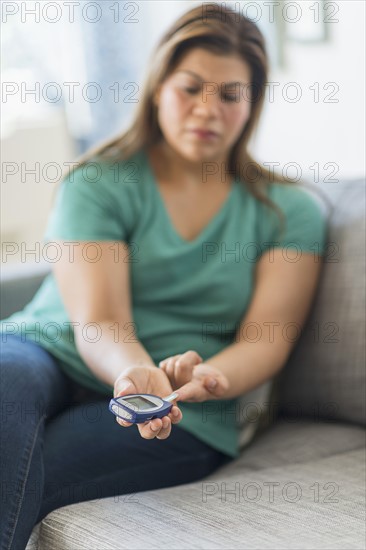 Woman sitting on sofa with mobile phone.