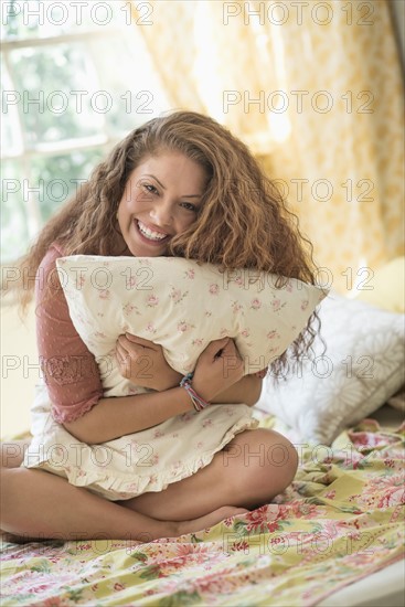 Portrait of woman embracing pillow.