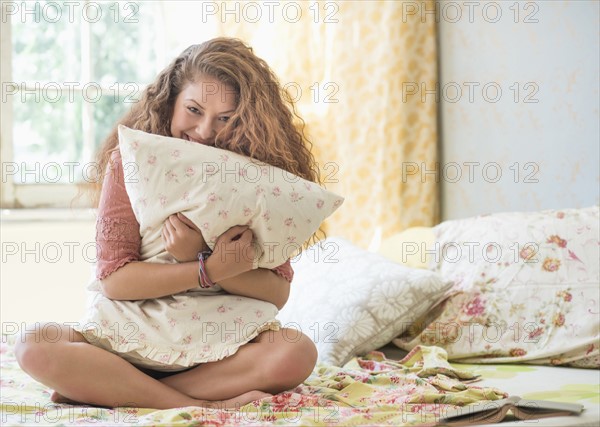 Portrait of woman embracing pillow.