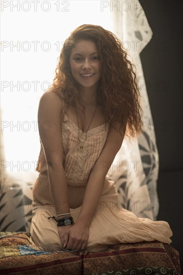 Portrait of stylish woman in window sill.