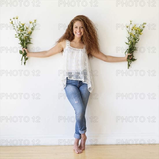 Portrait of woman with bunches of flowers in hands.