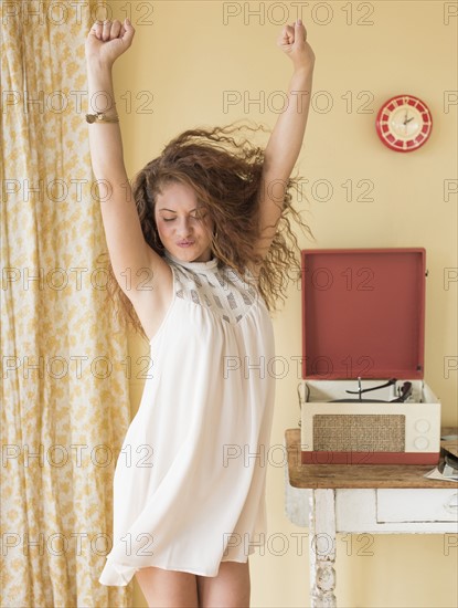 Portrait of woman dancing happily in room.