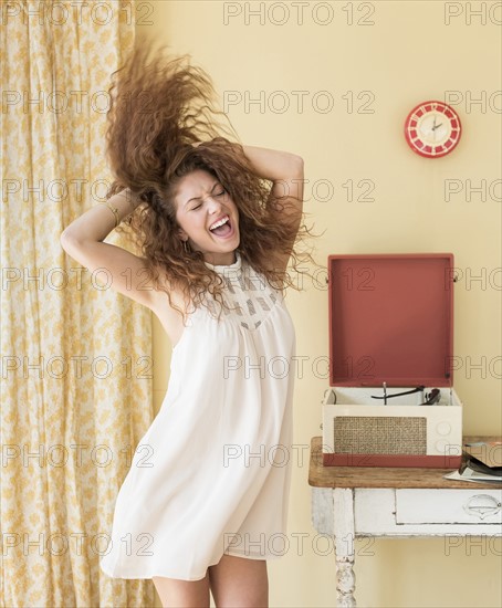 Portrait of woman dancing happily in room.