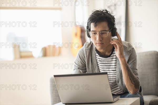 Man mixing music on laptop.