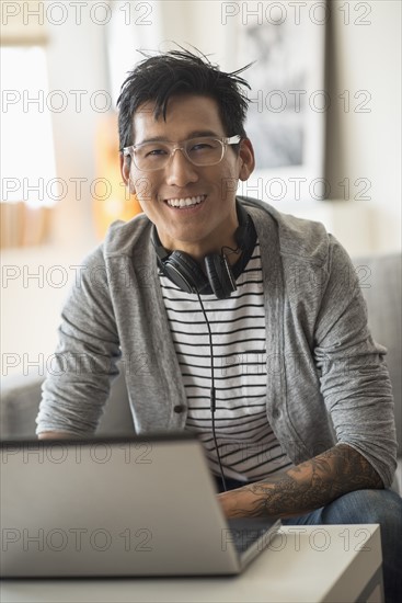 Portrait of man with headphones in front of laptop.