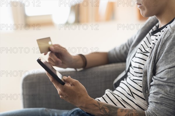 Man paying with credit card on tablet.