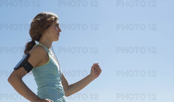 Side view of young woman jogging.