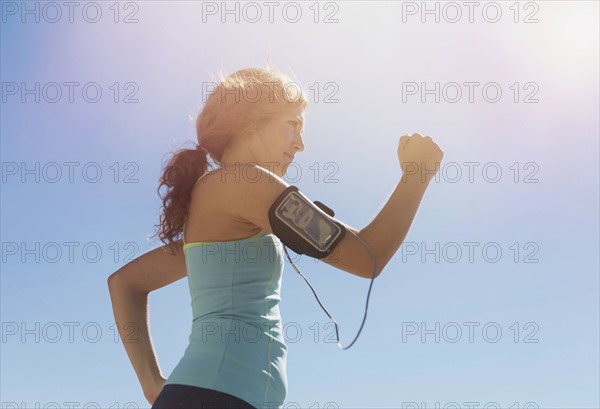 Side view of young woman power walking.