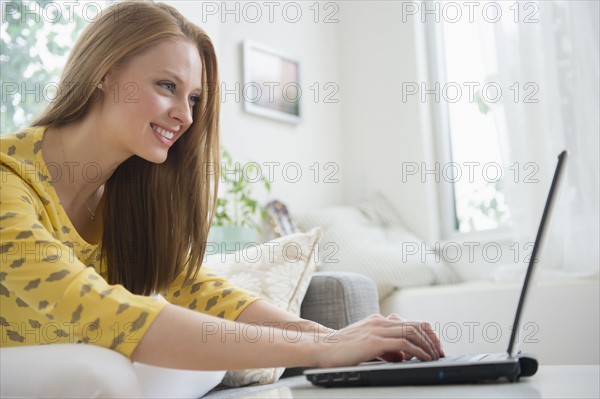 Young woman using laptop in living room