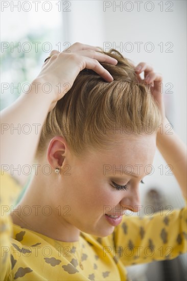 Young woman making hair bun