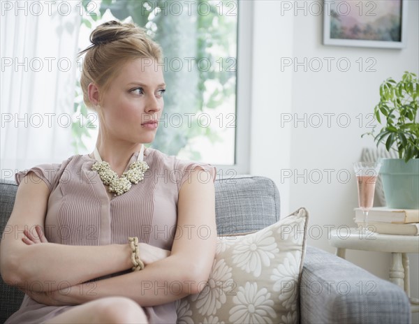 Upset young woman sitting on sofa