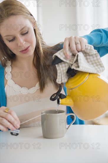 Young woman making tea