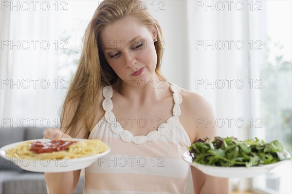 Woman choosing between pasta and salad