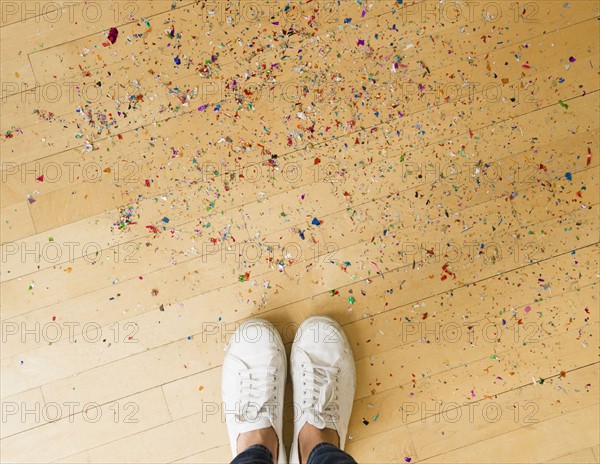 Woman's feet and confetti on floor