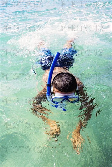 Boy (10-11) snorkeling in sea