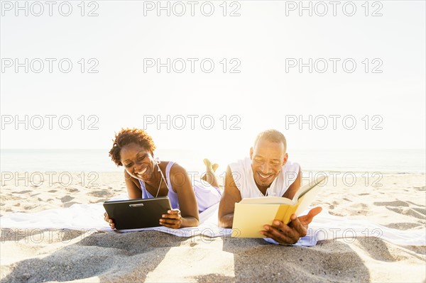 Man and woman reading on beach