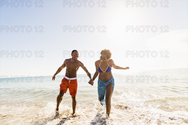 Mature couple running in sea