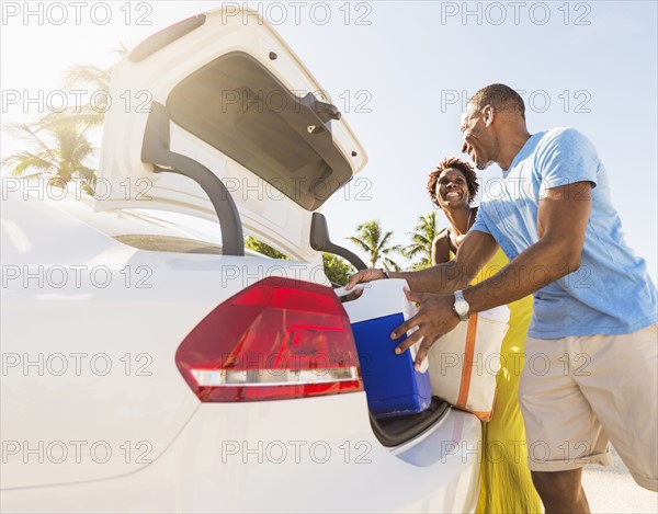 Mature couple loading car trunk