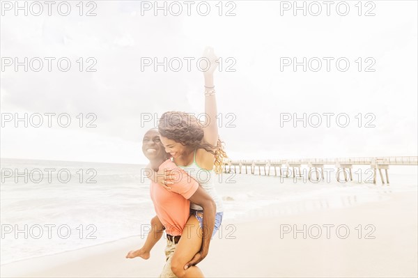 Young couple playing on beach