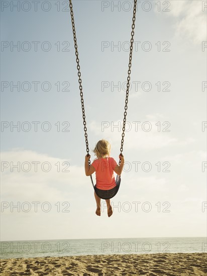 Girl (4-5) swinging on beach