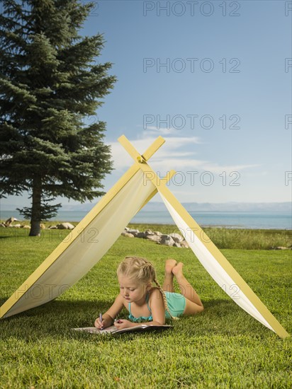 Girl (2-3) lying in tent